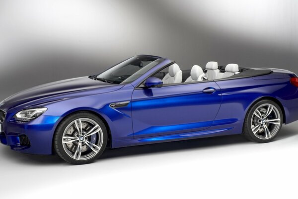 Stylish blue convertible on a gray background