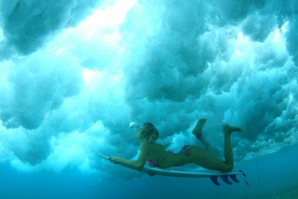 Chica sexy en el océano en una tabla de surf