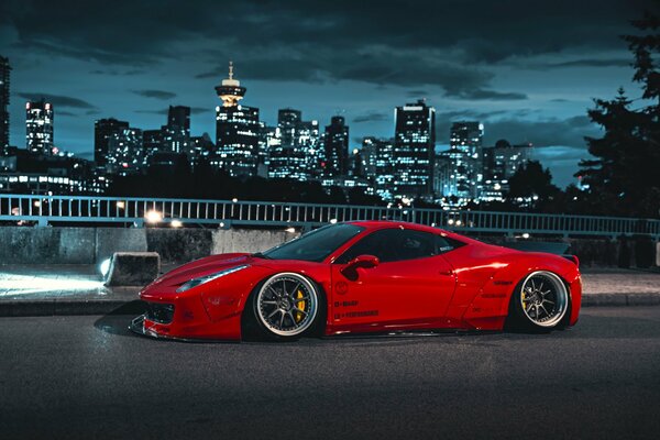 Roter Ferrari vor dem Hintergrund der Lichter der Nachtstadt