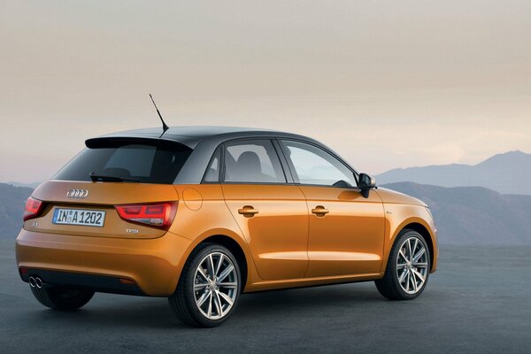 Orangefarbener Audi a1 in den Bergen