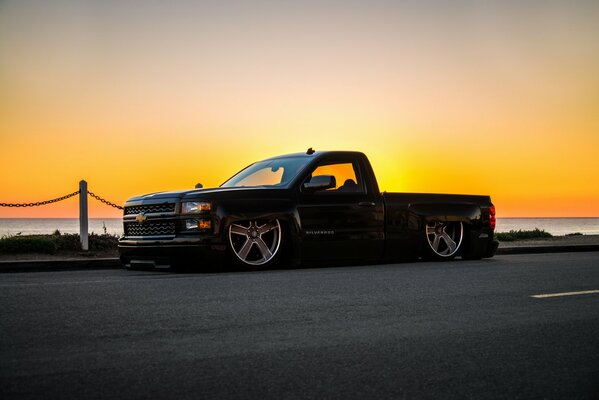 Black chevrolet silverado pickup truck at sunset