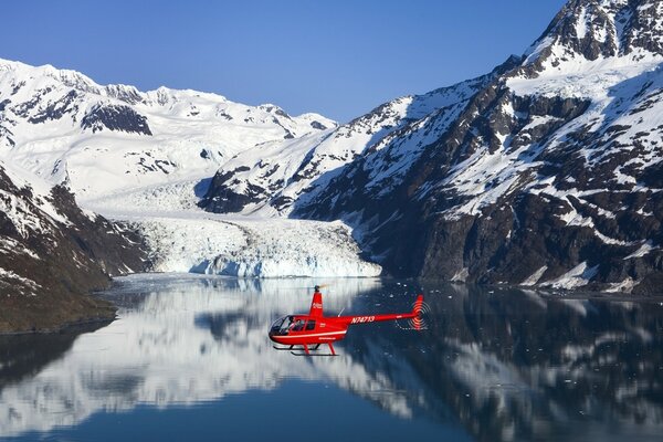 Rescue helicopter lands on the surface of a mountain lake