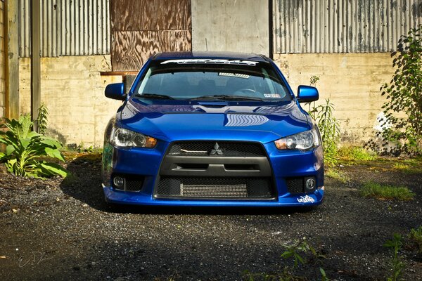 Mitsubishi Lancer azul en el patio de la casa