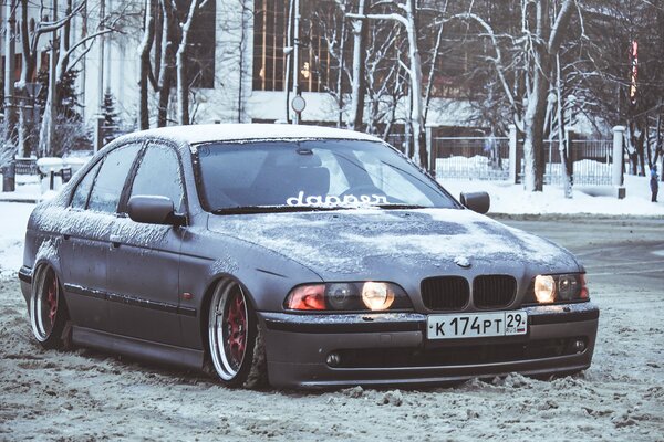 Ein verschneiter BMW auf einer Winterstraße