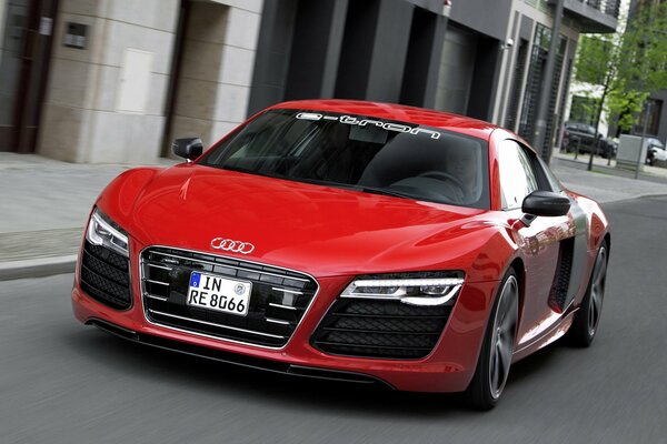 A beautiful red Audi is parked in the city