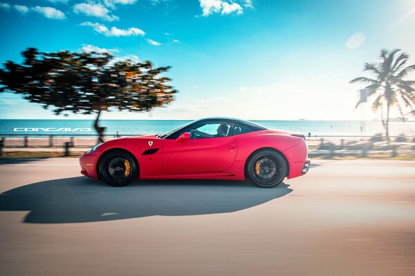 Roter matter Ferrari auf dem Hintergrund von Straße und Himmel