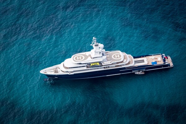 The yacht sails on the blue abyss of the ocean