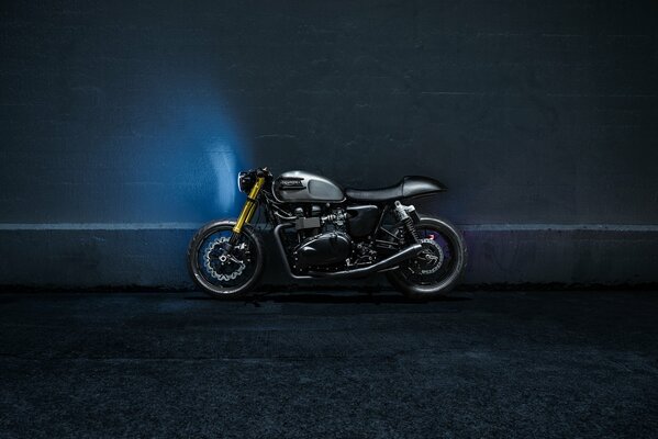 Moto noire près du mur bleu