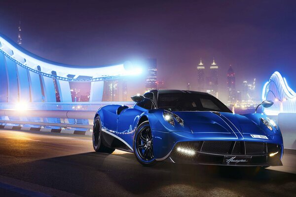 Blauer Supersportwagen Pagani Huayra vor Nachtstadthintergrund