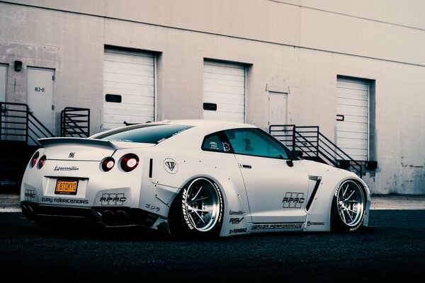 Libertad. caminar en un coche deportivo japonés bajo blanco nissan gt-r r35. vista posterior