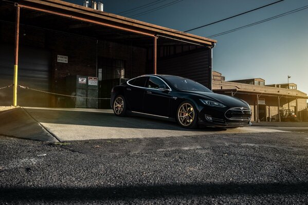 Czarny Tesla Model S opuszczający Garaż