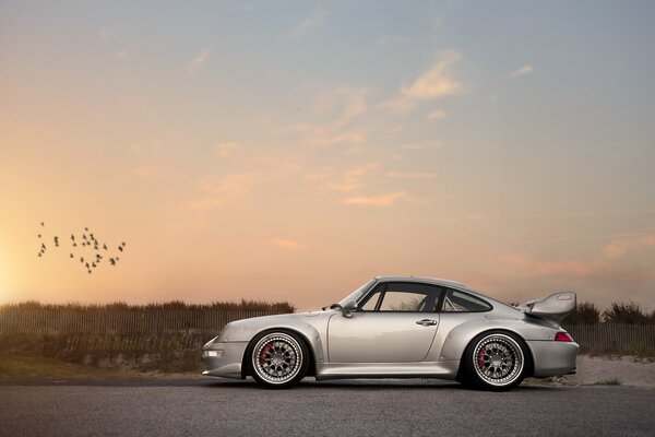 Argento Porsche contro il cielo al tramonto