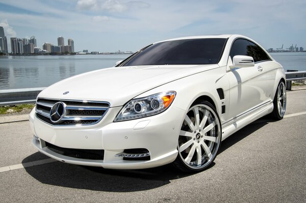 Mercedes blanco cl63 amg, v8 a lo largo de la costa del agua