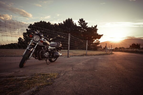 Moto suzuki estacionada en medio de la puesta de sol