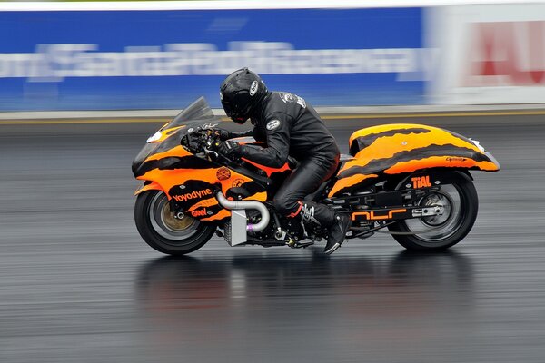 Moto arancione nel traffico in pista