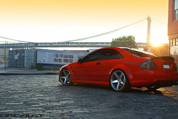 Hermosa puesta de sol en la ciudad. Mercedes rojo