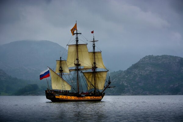 Eine Fregatte mit russischer Flagge im norwegischen Meer. Die Berge