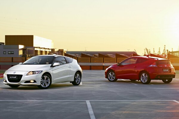 Honda blanco y rojo en el fondo de la puesta de sol de la ciudad