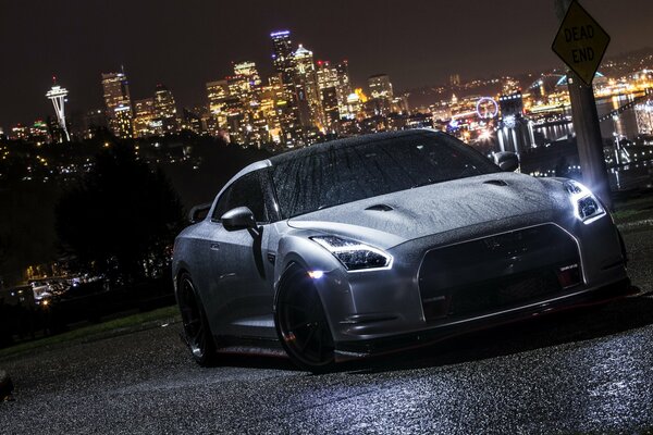Nissan GTR at the highest point of the city in wet weather