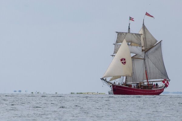 Un gran barco con velas navega por el mar