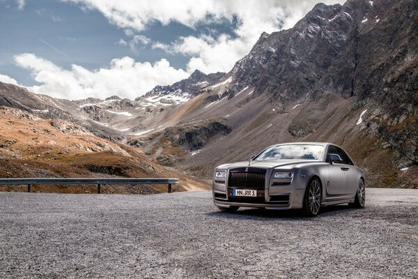 Coche de plata de lujo en el fondo de las montañas