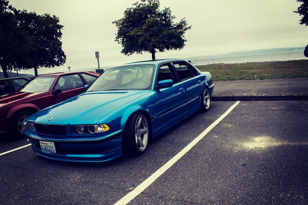 BMW E38 de alta velocidad en el estacionamiento