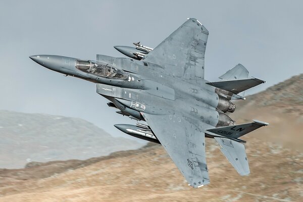 Beautiful F15E military fighter over the mountains