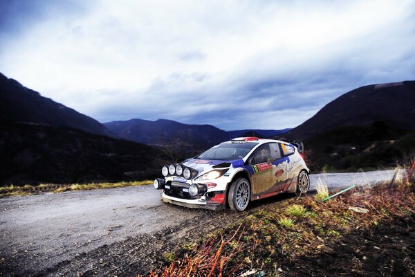 Ford fiesta rally race against the backdrop of mountains