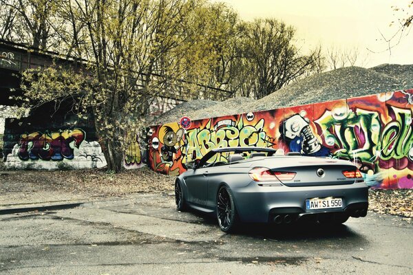 Convertible negro y graffiti en la pared