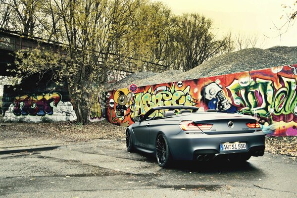 Czarny kabriolet i graffiti na ścianie