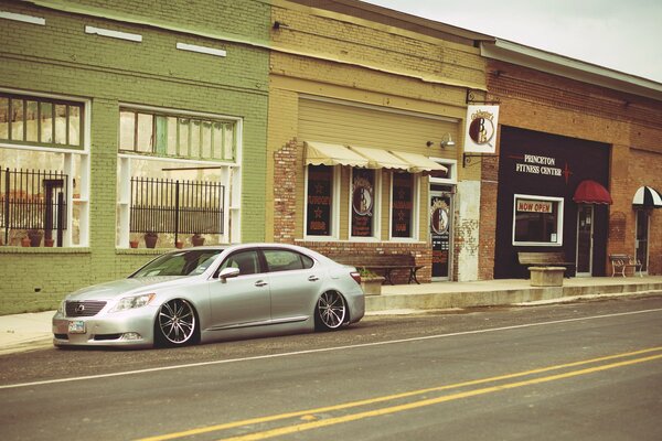 Un Lexus plateado en una pequeña tienda en la calle