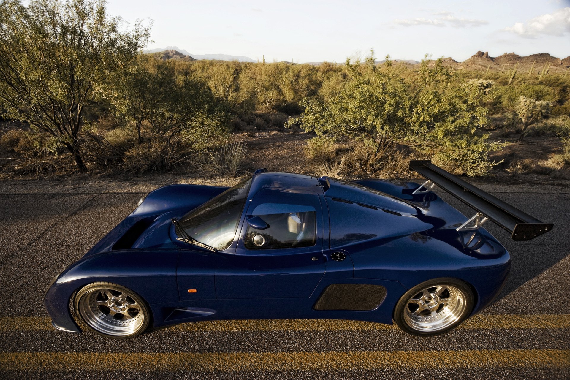 ultima gtr1 blue supercar road trees desert sky