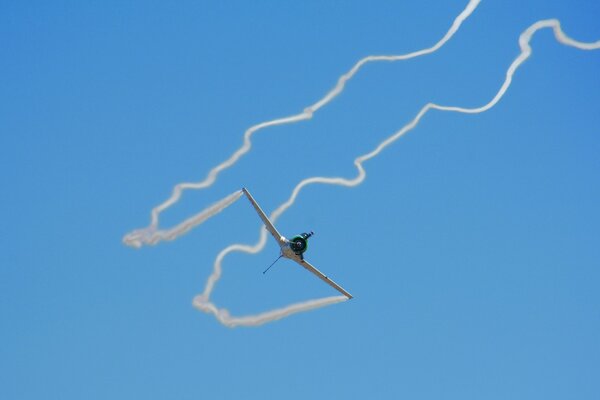 El avión deja huellas blancas intrincadas en el cielo azul