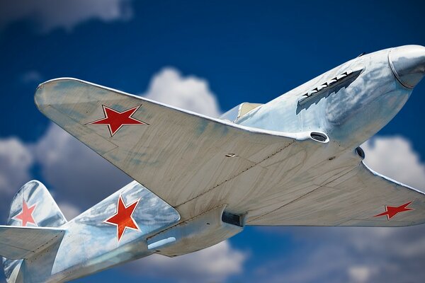 A plane gliding in the clouds. Victory Day