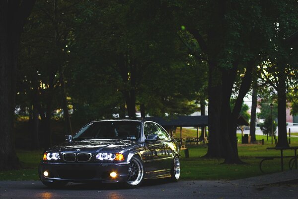 Por la noche, cerca del parque bmw, e46 con los faros encendidos