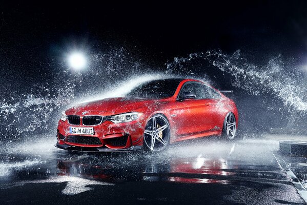 Red juicy BMW with water splashes