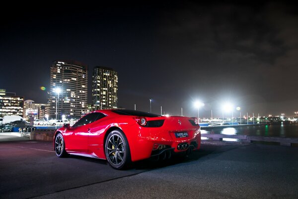Ferrari rossa sullo sfondo della città di notte