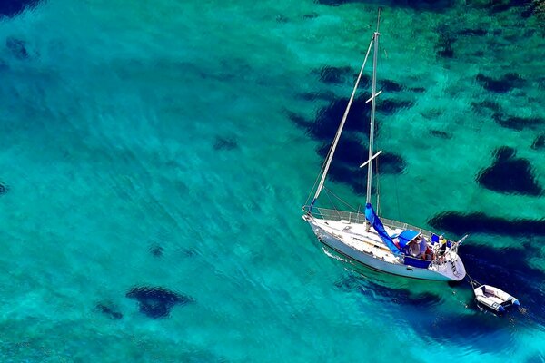 Die Yacht schwimmt auf blauem Wasser