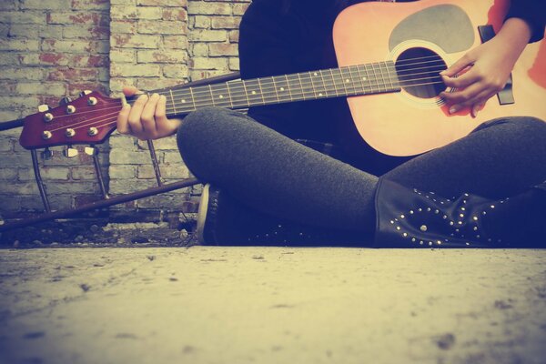 Chica sentada tocando la guitarra