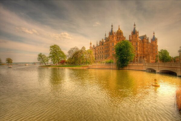 A large building near the river and the bridge at sunset