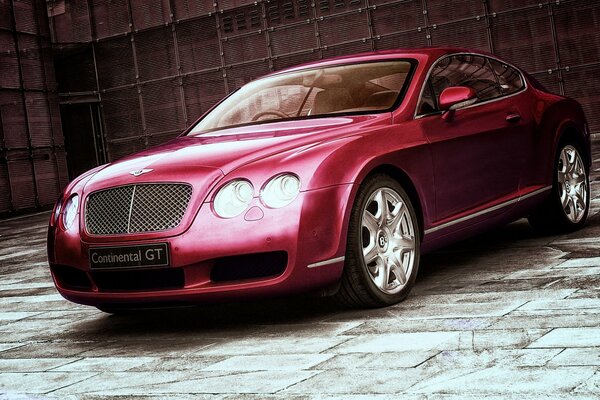 Czerwony kontynentalny Bentley na tle ściany
