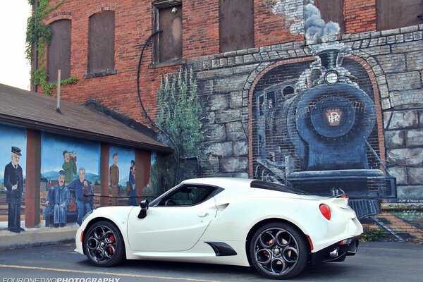 Alfa Romeo blanc contre le mur avec un motif de locomotive à vapeur