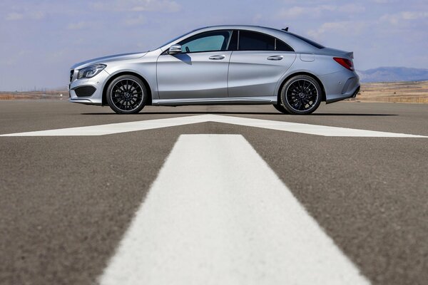 Mercedes-benz sedán gris vista lateral sobre asfalto