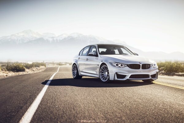 BMW M3 sur fond de route goudronnée