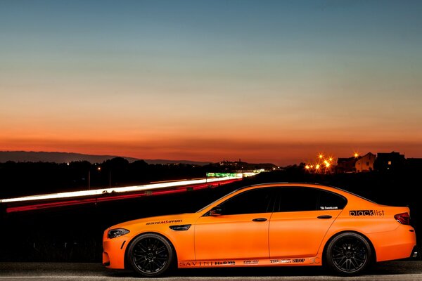 Voiture orange sur fond de ville de nuit