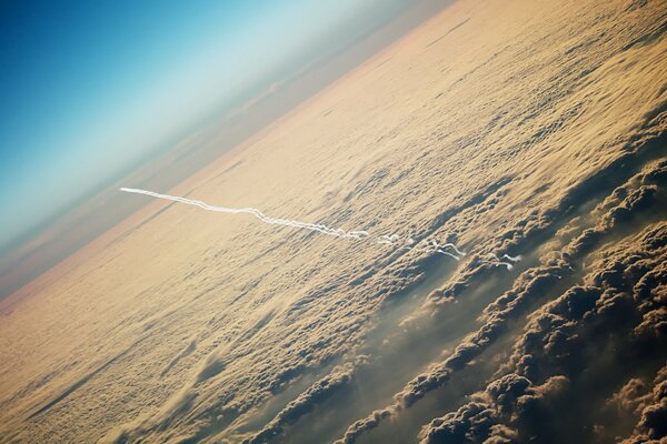Eine Spur von einem Flugzeug am Himmel vor einem Hintergrund von Wolken