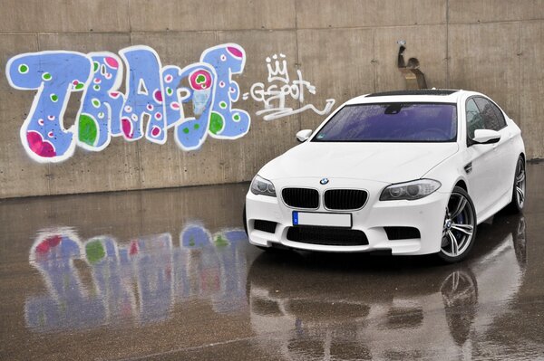 Bmw M5 białe auto na tle graffiti