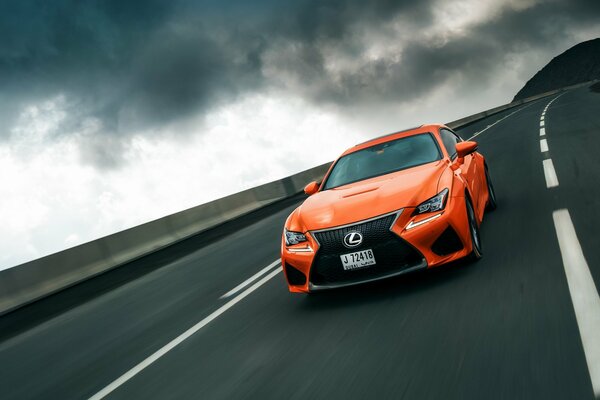 Orange Lexus se précipite sur la piste sous le ciel étoilé