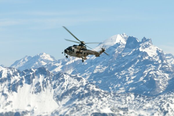 Hubschrauber auf dem Hintergrund der schönen weißen Berge