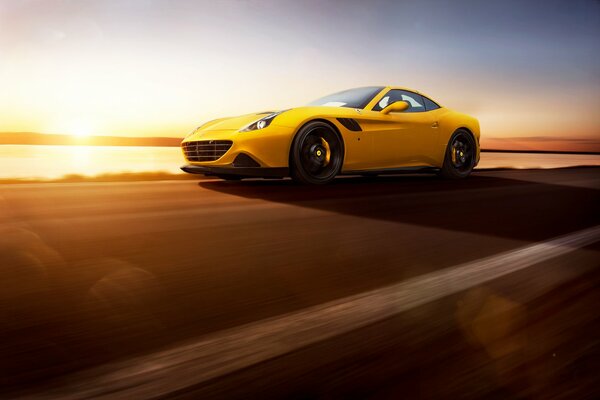 Yellow ferrari supercar at sunset